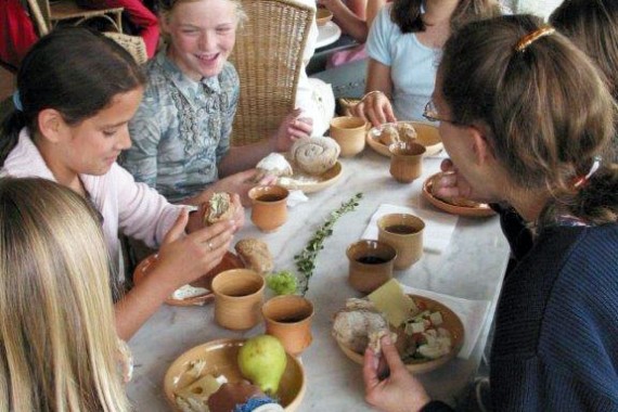 Kinder an gedecktem Tisch bei Römischer Brotzeit