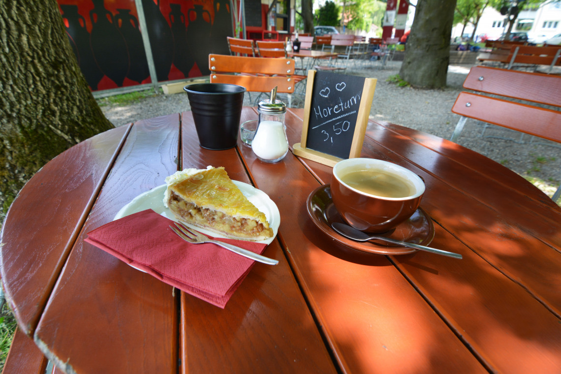 Gartentisch mit Apfelkuchen und Tasse Kaffee