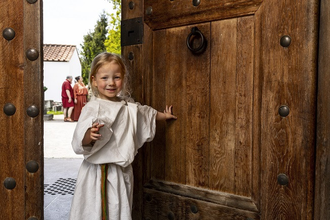 Ein Mädchen öffnet die Tür im Tempelbezirk des Museums