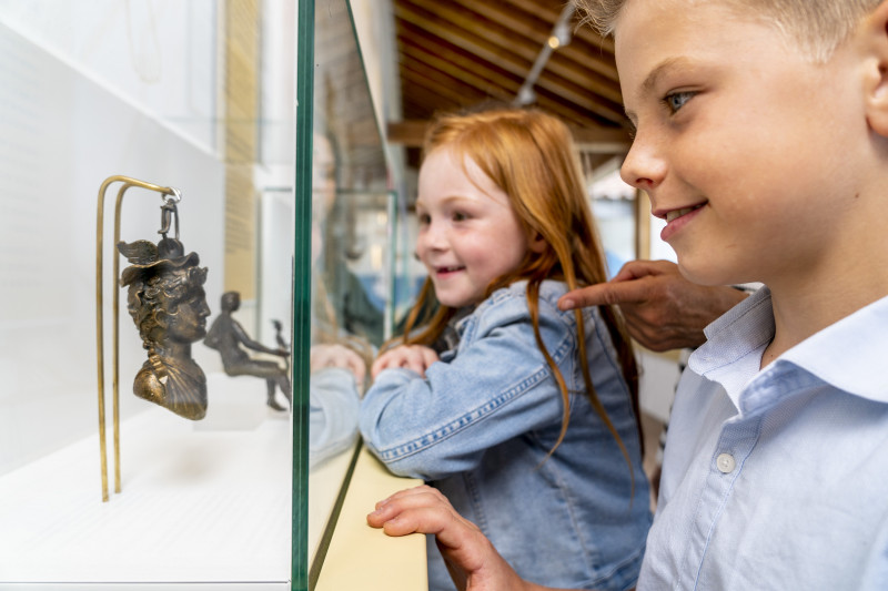 Zwei Kinder bestaunen den Inhalt einer Vitrine in der Ausstellung