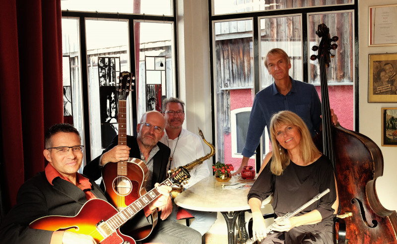 Die Band mit Instrumenten um einen Tisch gruppiert