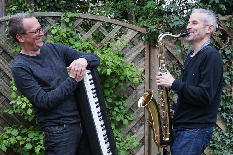 Die Musiker mit ihren Instrumenten, einem Keyboard und einem Saxophon, stehen sich gegen&uuml;ber
