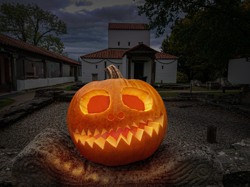 Leuchtender Halloween-K&uuml;rbis vor dem Tempelbezirk des APC bei Nacht